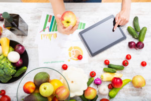 tablet computer on table with fruits and vegetables