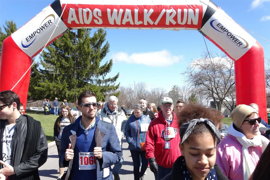 people walking under banner reading AIDS Walk/Run